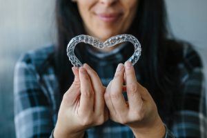 Patient Making Heart-Shape with Dental Aligners